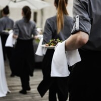 Waiter carrying plates at event