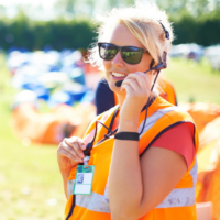 event and crowd control with a female officer using a headset microphone for protection