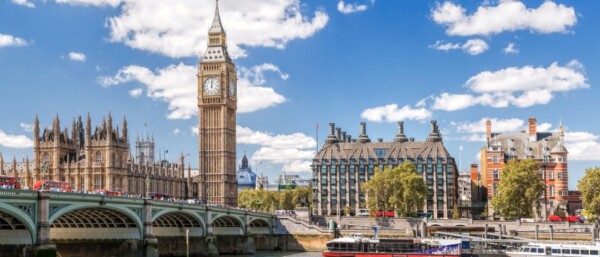 Famous Big Ben with bridge over Thames and tourboat on the river