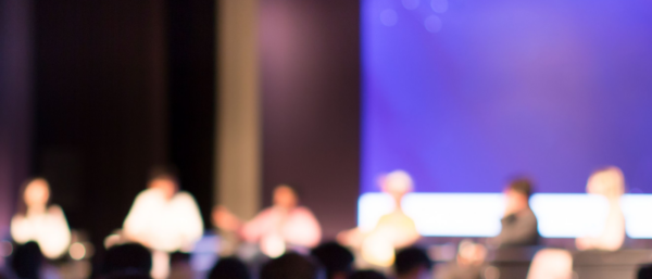 Blurred image of a panel discussion at an event